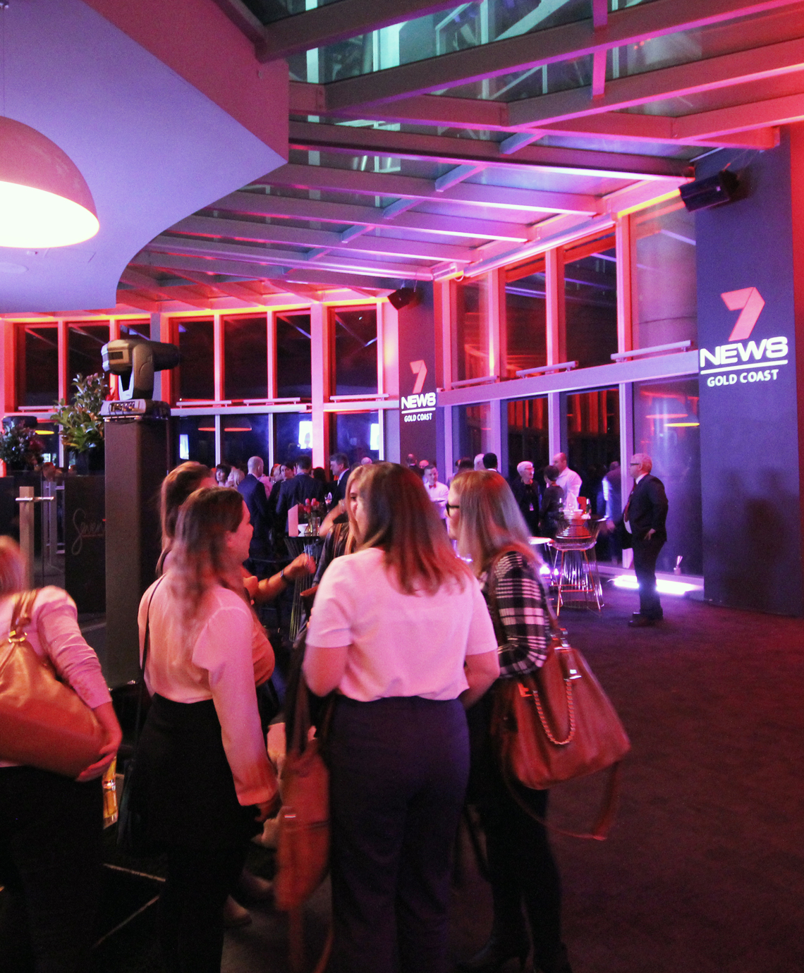 Guests gathered in a pink-lit event foyer.
