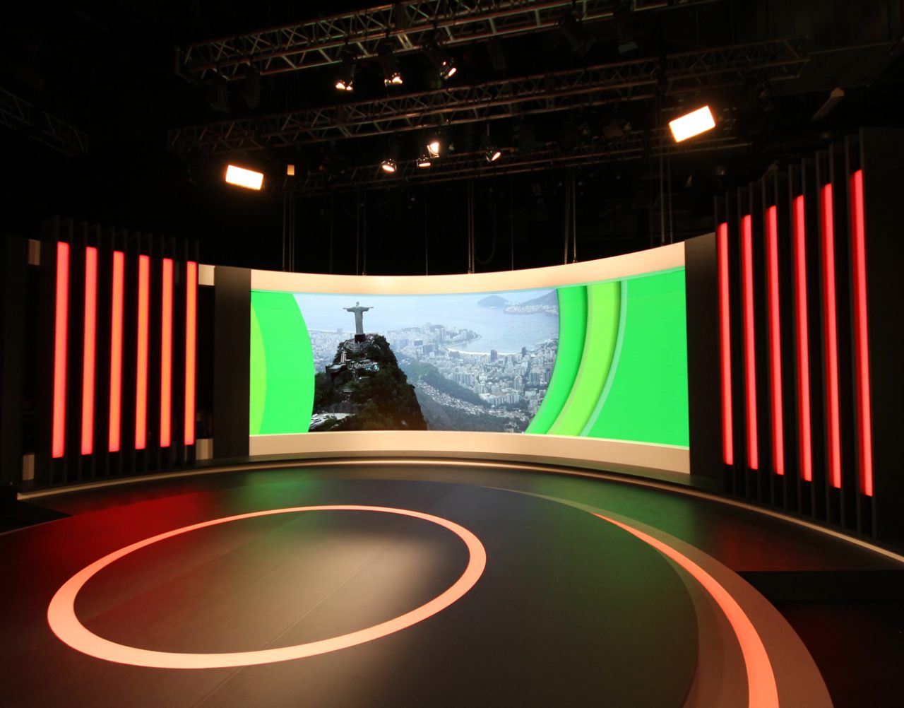 Curved studio display showing Rio scenery framed by green graphics.
