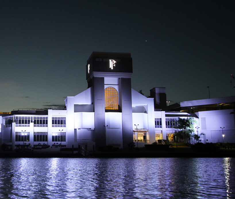 Central Myer entrance tower at Pacific Fair illuminated white at night.