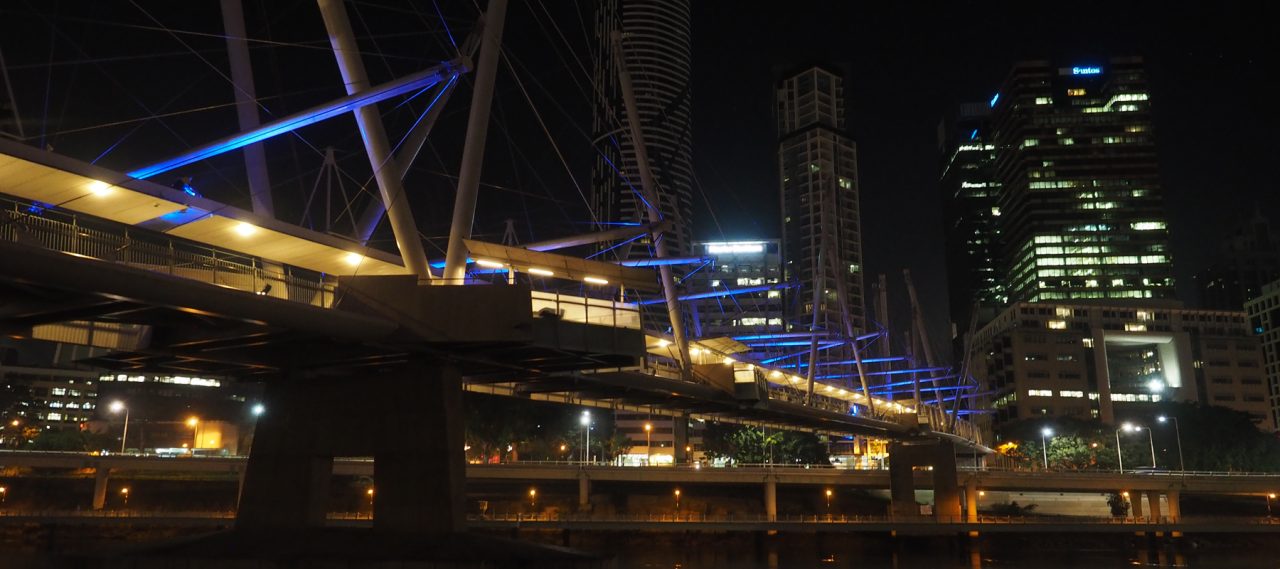 View along the underside of Kurilpa Bridge with blue-lit structural elements.