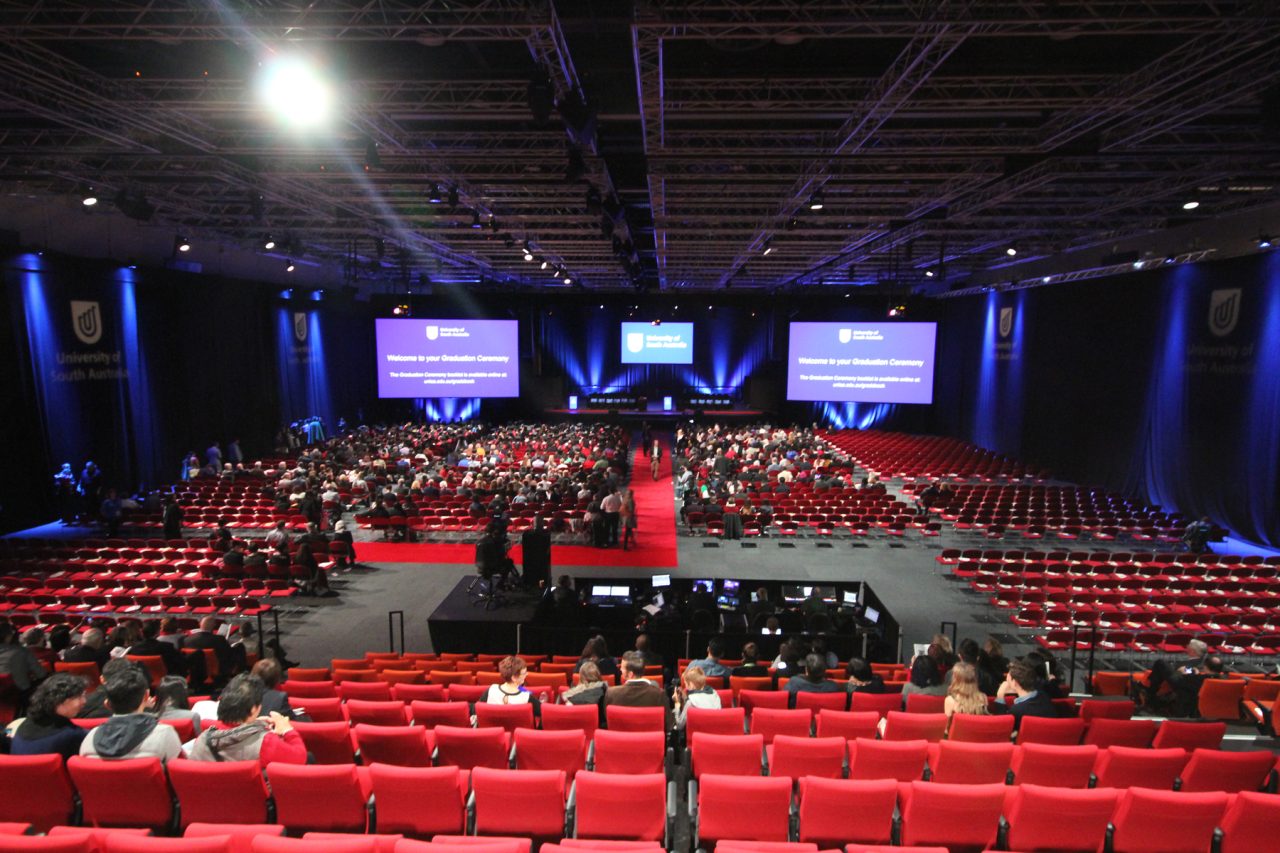Central aisle through red seating towards the presentation screens in Adelaide Convention Centre.