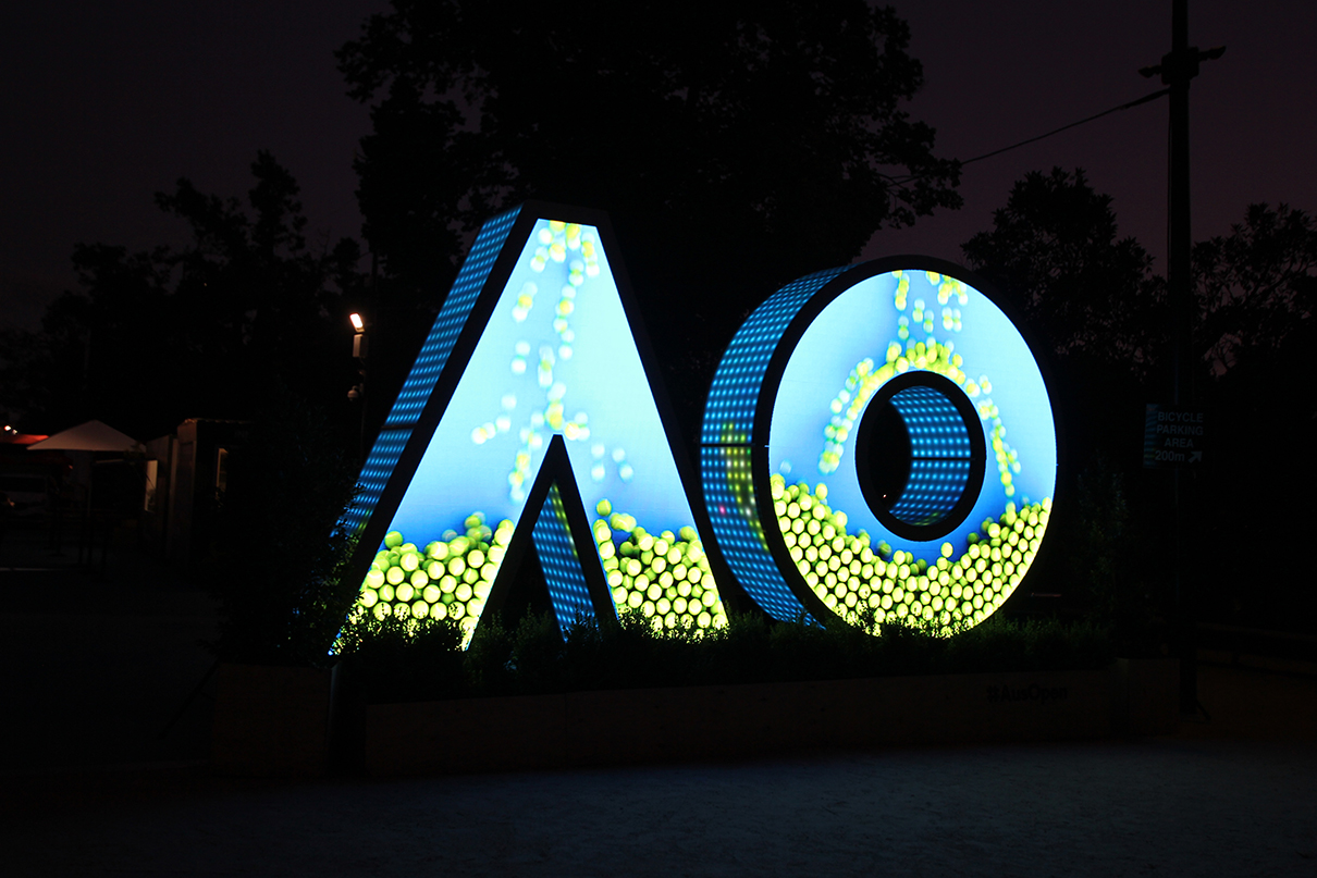 Blue and yellow dotted patterns illuminate the AO digital sign at night.