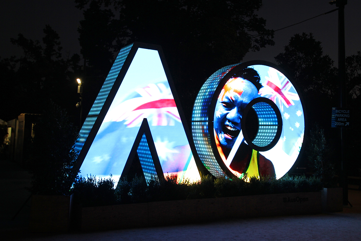 Bright video imagery across the AO digital sign at night.