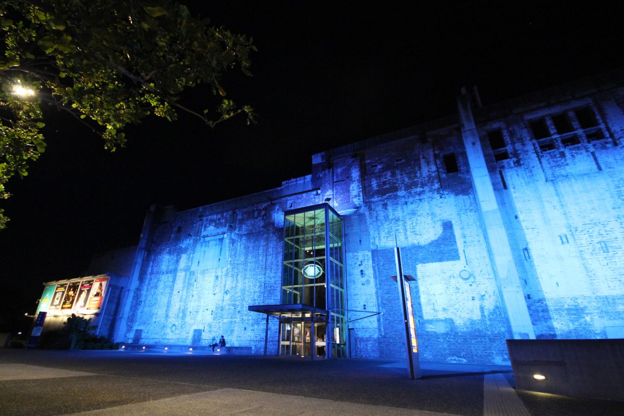 Wide night view of blue architectural lighting across Brisbane Powerhouse.