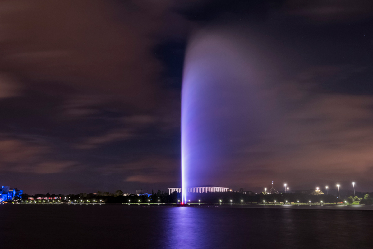Purple illumination through the Captain Cook Memorial Jet above the lake.