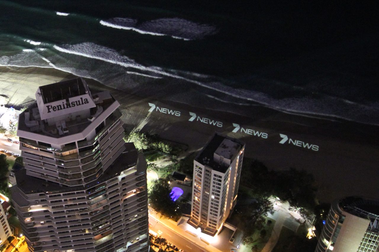 View down past high-rise buildings towards the illuminated beach during the Channel 7 News Gold Coast launch.