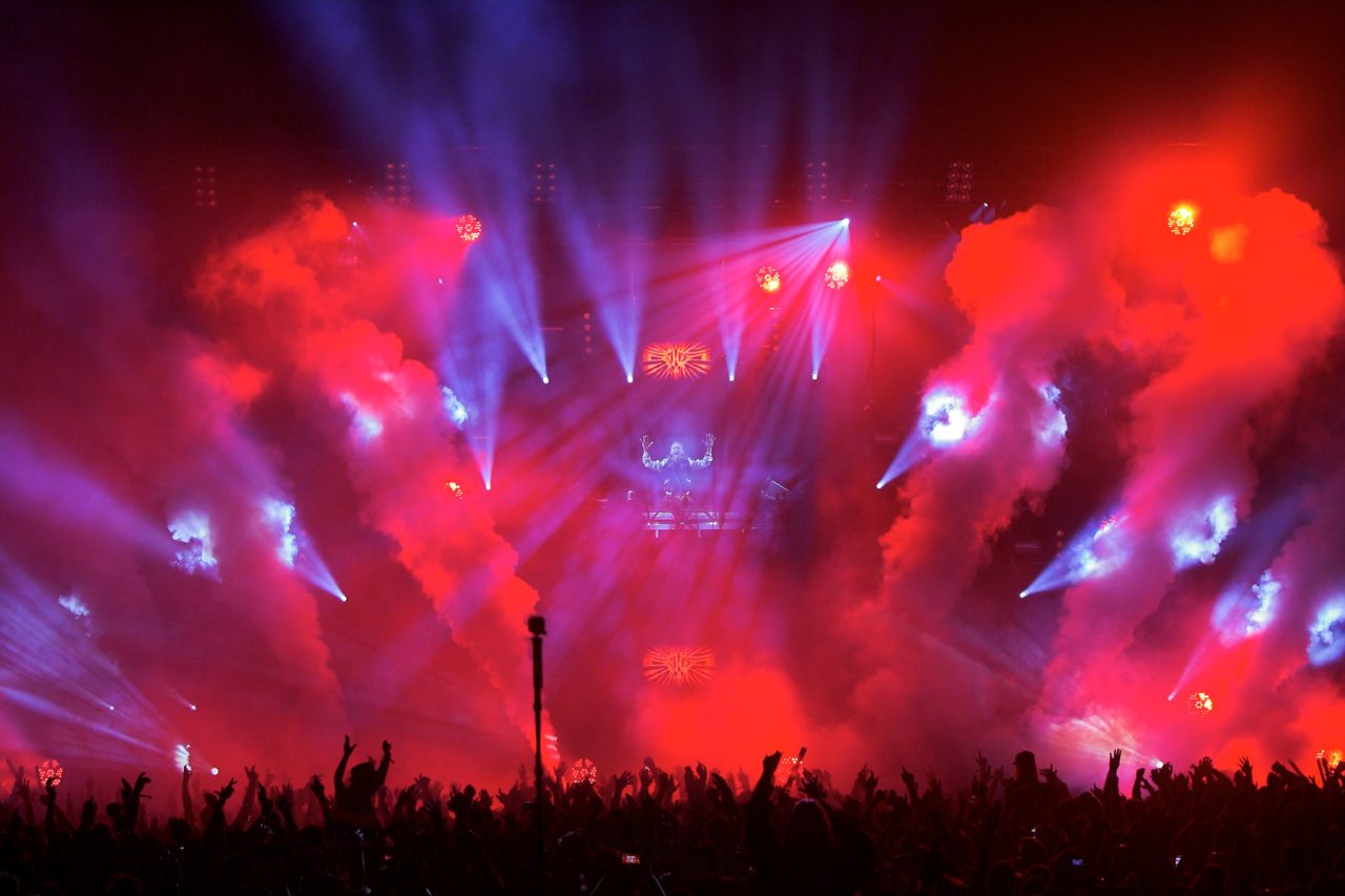 Red haze and blue beams over the crowd at David Guetta's show.