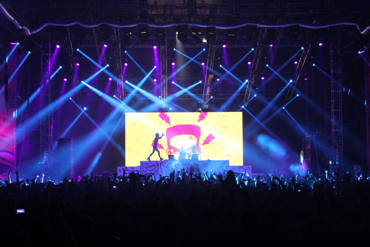 Crossing blue beams around a colourful central video screen at Future Music Festival.