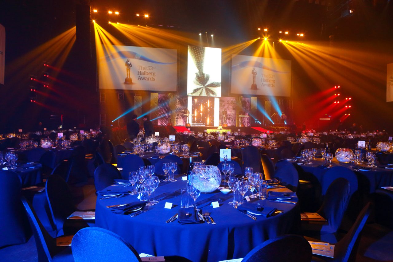 Blue-lit banquet tables beneath amber stage beams at the Halberg Awards.
