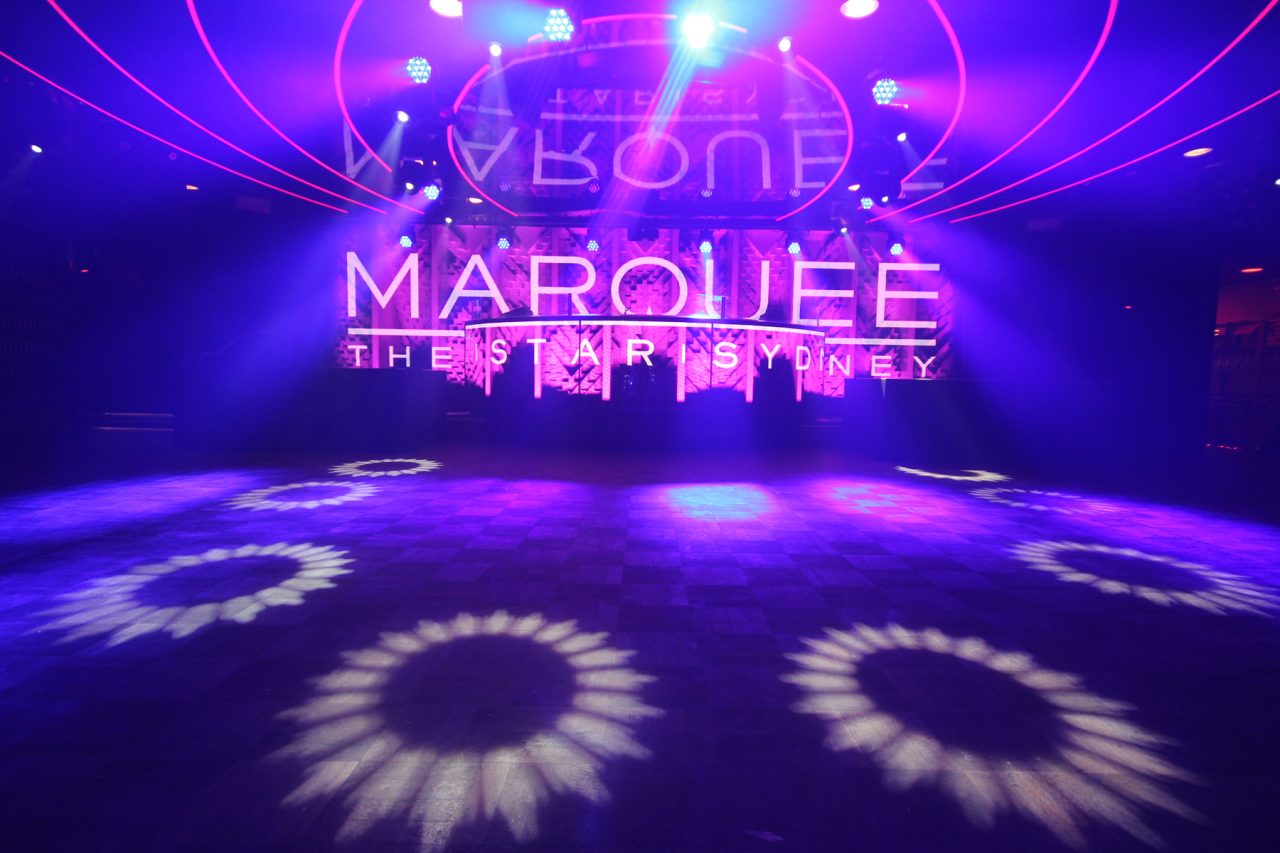 Circular light patterns across the dance floor beneath the Marquee screen at The Star Sydney.