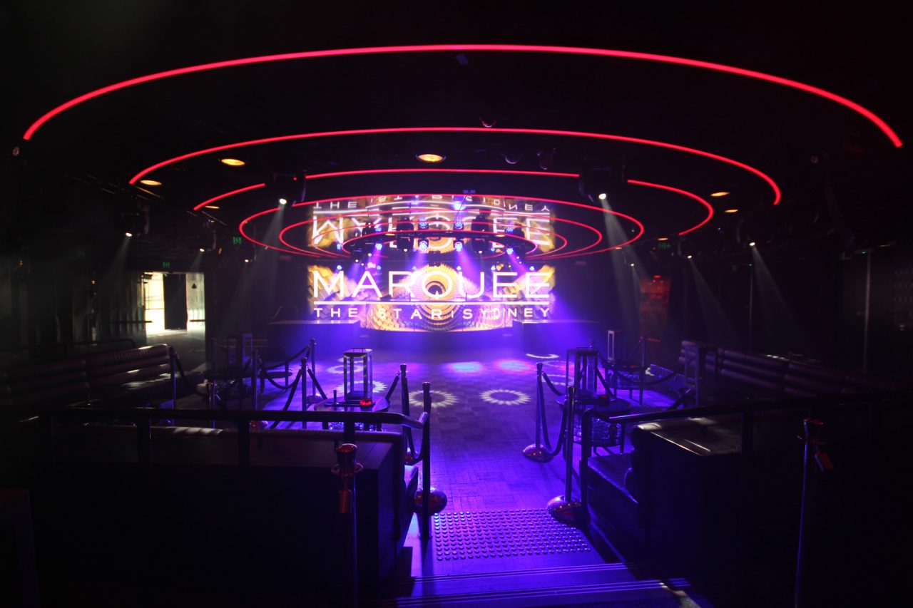 Wide view of Marquee's dance floor, screen and red ceiling light rings.