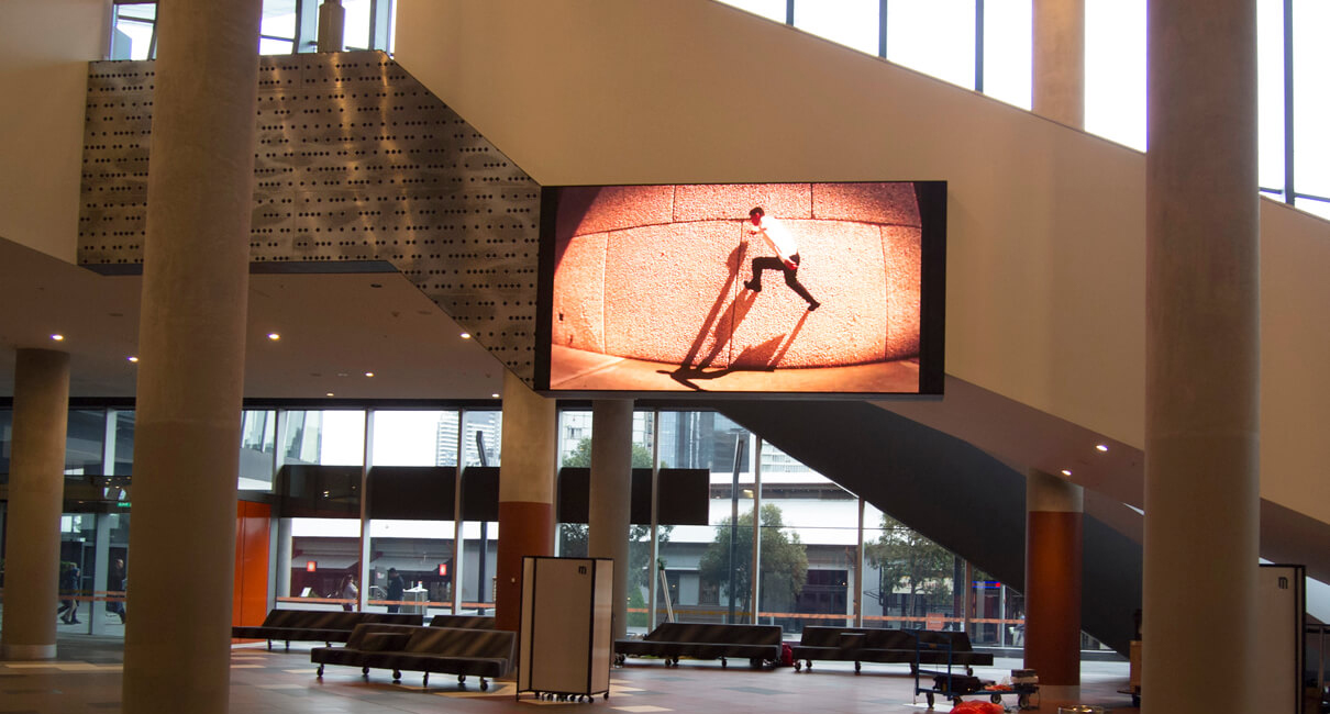 Indoor video advertising screen beside the stairs at MCEC.