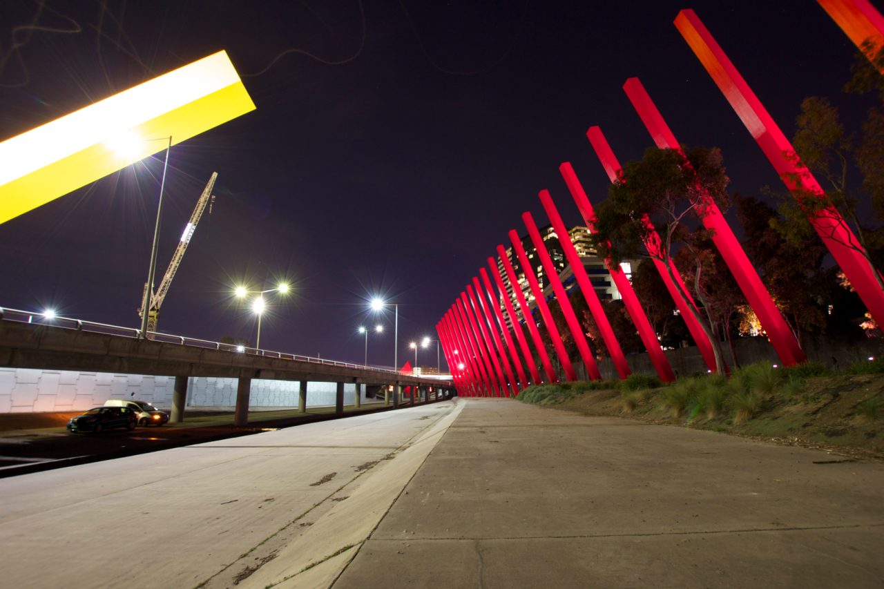 Row of illuminated Red Sticks beside the promenade in Melbourne at night.