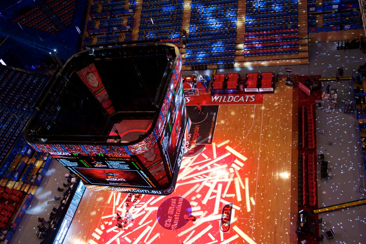Lighting patterns across the Perth Wildcats court beneath the video scoreboard.