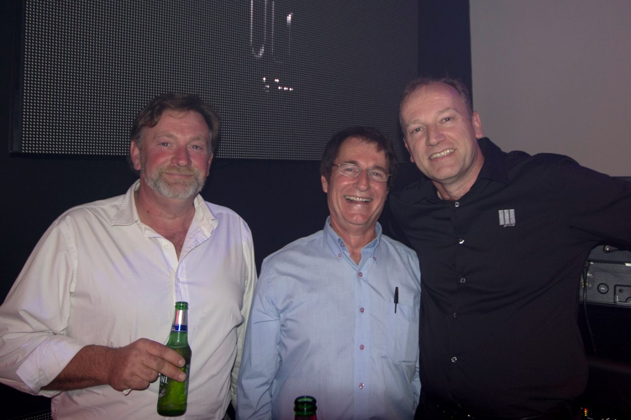 Three guests posing in front of a showroom display.