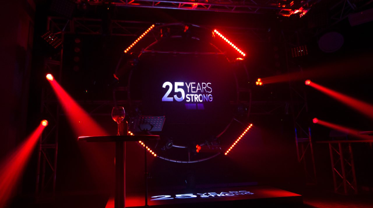 ULA 25 Years Strong graphic surrounded by red stage beams.
