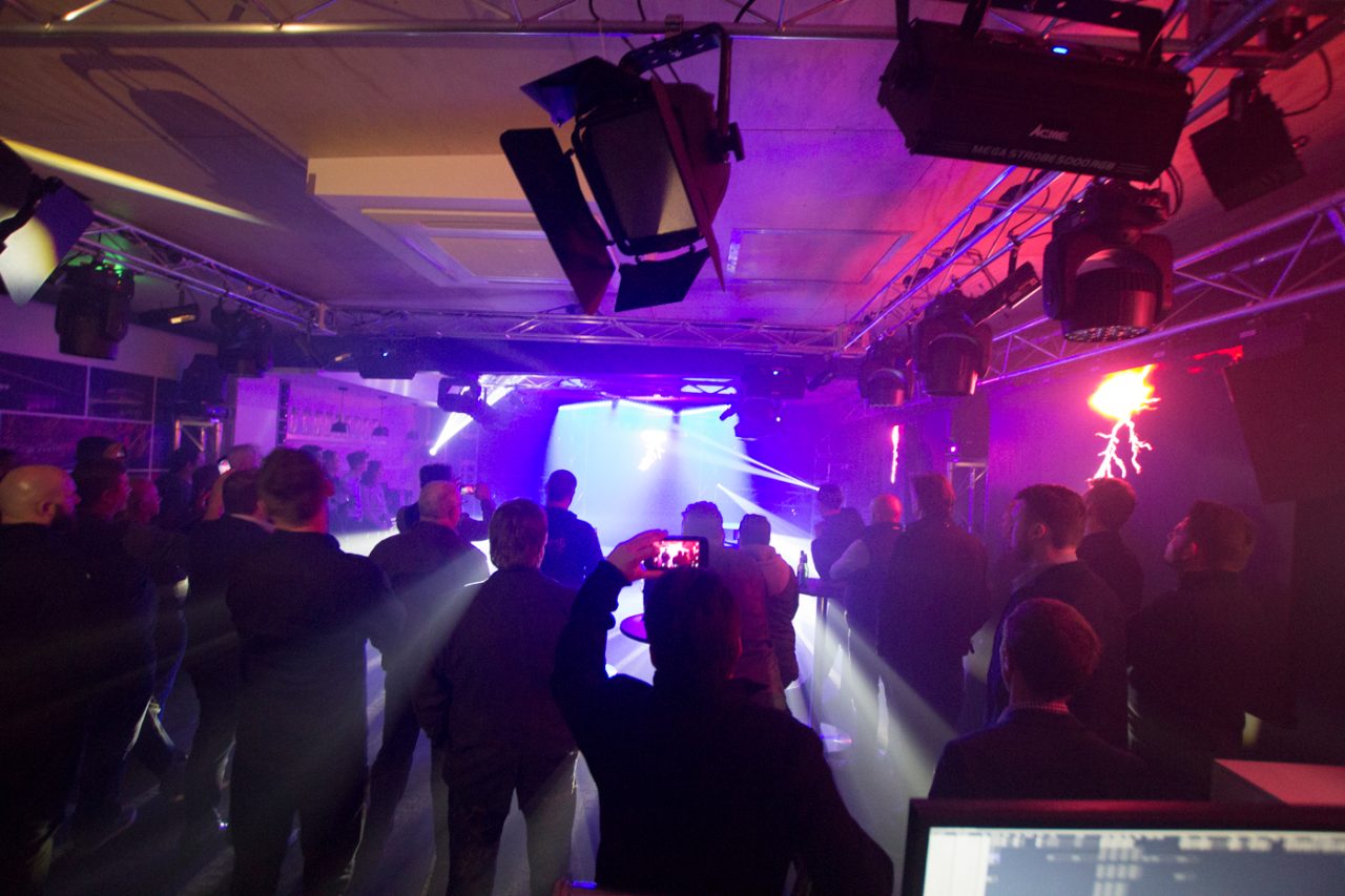 Guests watching purple and white beams at the Melbourne showroom opening.