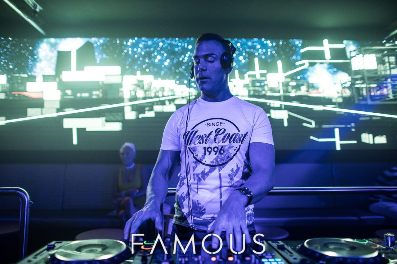 DJ performing in front of a bright LED backdrop at Famous Brisbane.