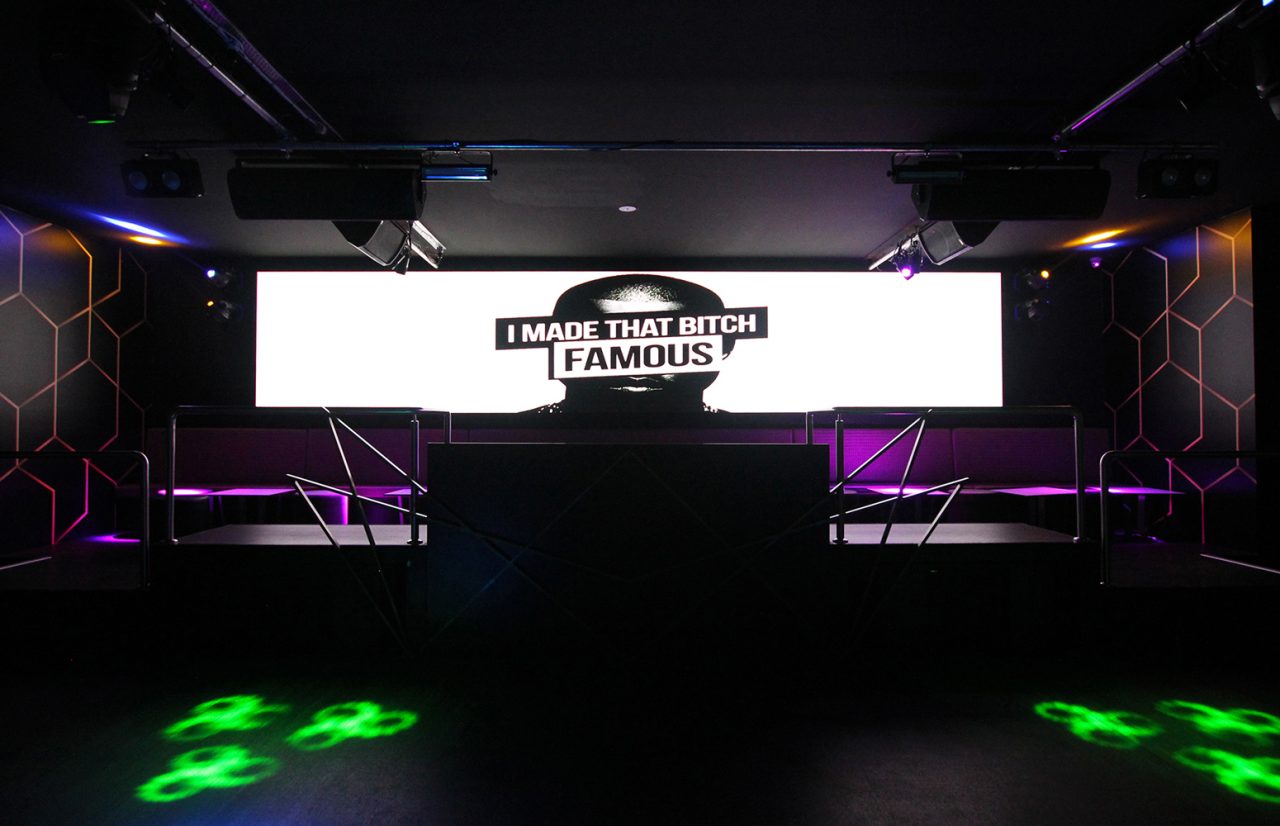 White promotional display above the DJ booth at Famous Night Club.