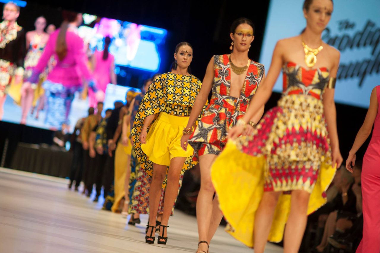 Models in colourful outfits walk the FashFest 2017 runway in front of a live video screen.