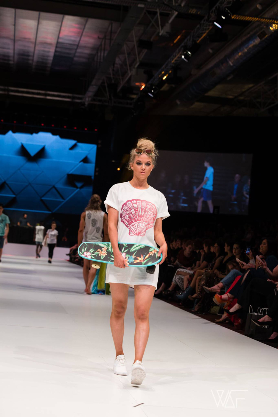 Model in a colourful printed outfit walking the FashFest runway.