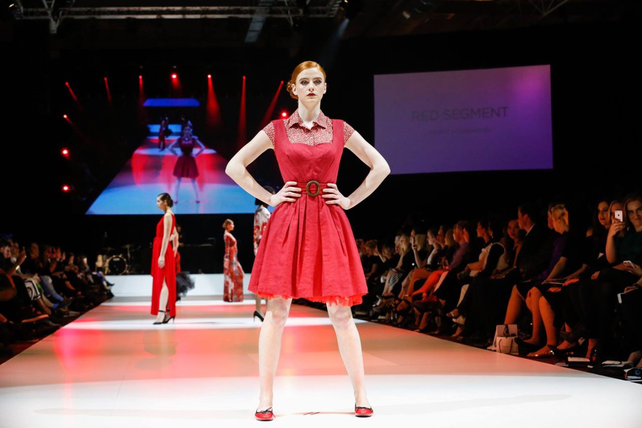 A model in a red dress poses on the FashFest 2017 runway.