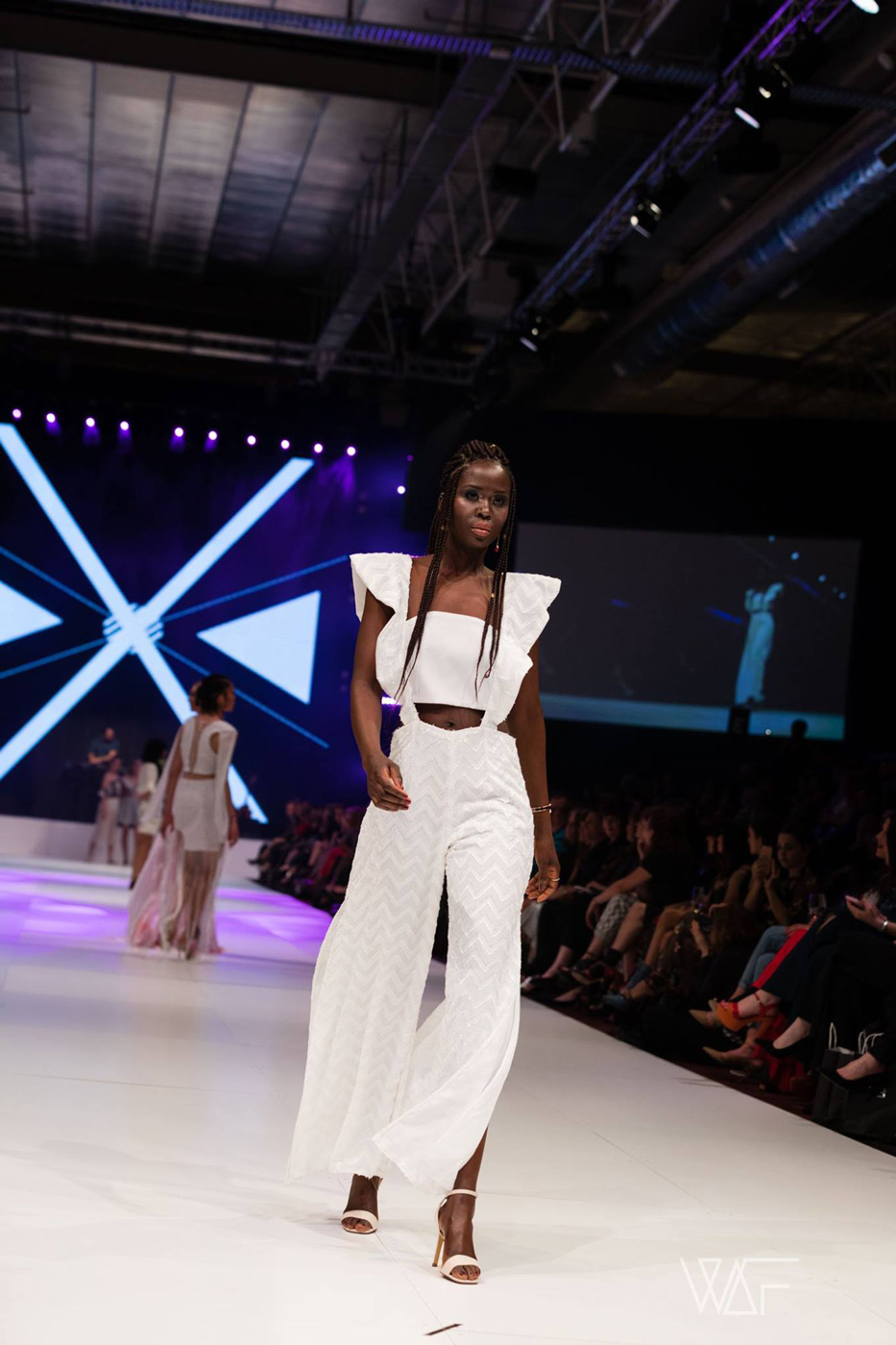Model wearing a flowing white outfit on the FashFest 2017 runway.