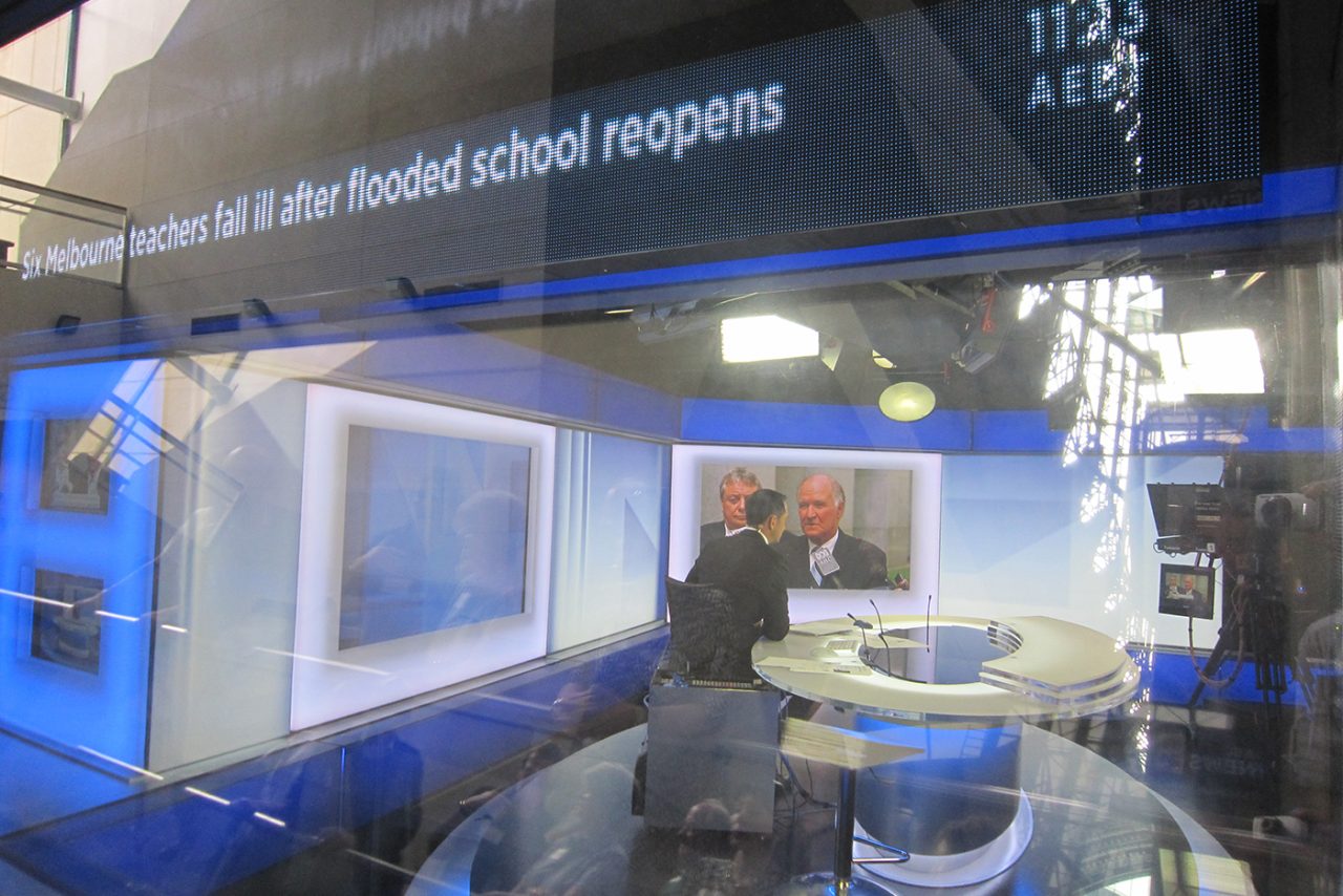 Close view of the scrolling headline display above the ABC News 24 studio window.