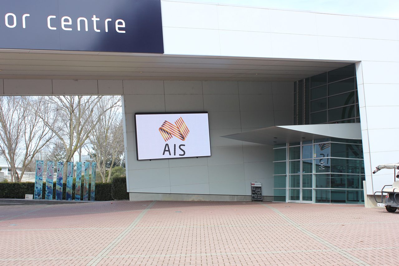 AIS branding on the digital screen beneath the visitor centre entrance canopy.