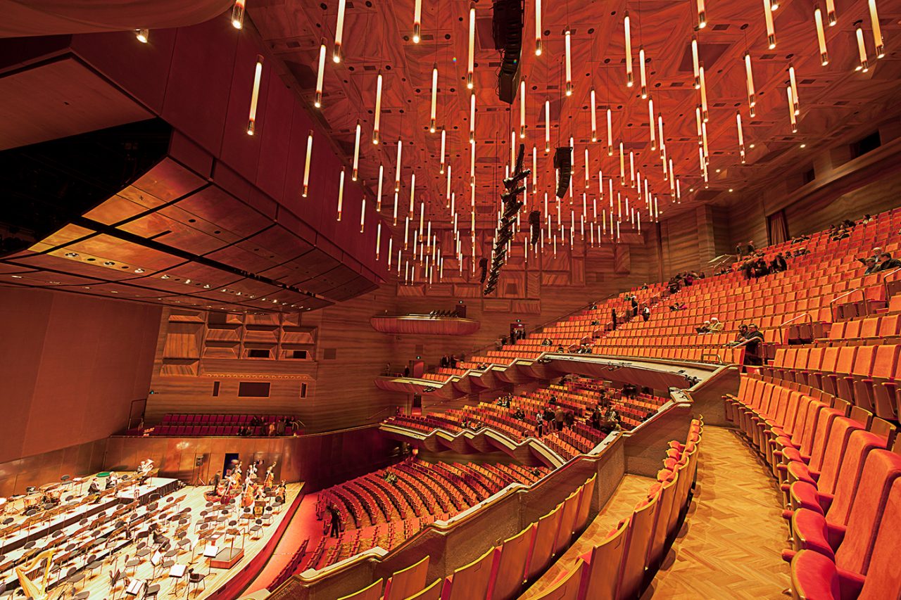 Warm-lit Hamer Hall viewed across the curved balcony seating.