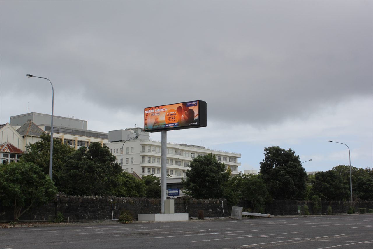 Wide roadside view of the digital billboard at ASB Showgrounds beneath an overcast sky.