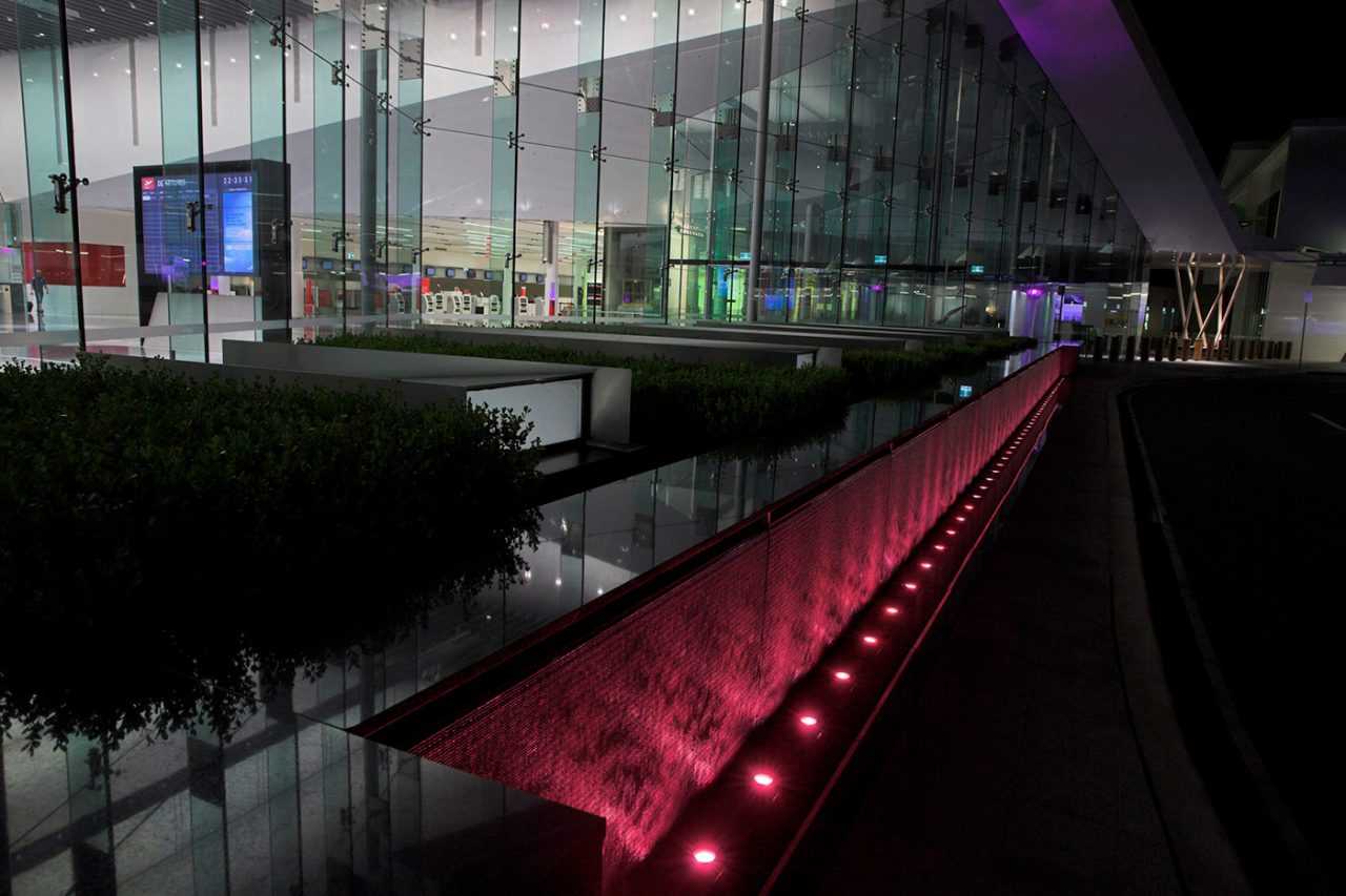 Perspective view along a red-lit water channel outside Canberra Airport.