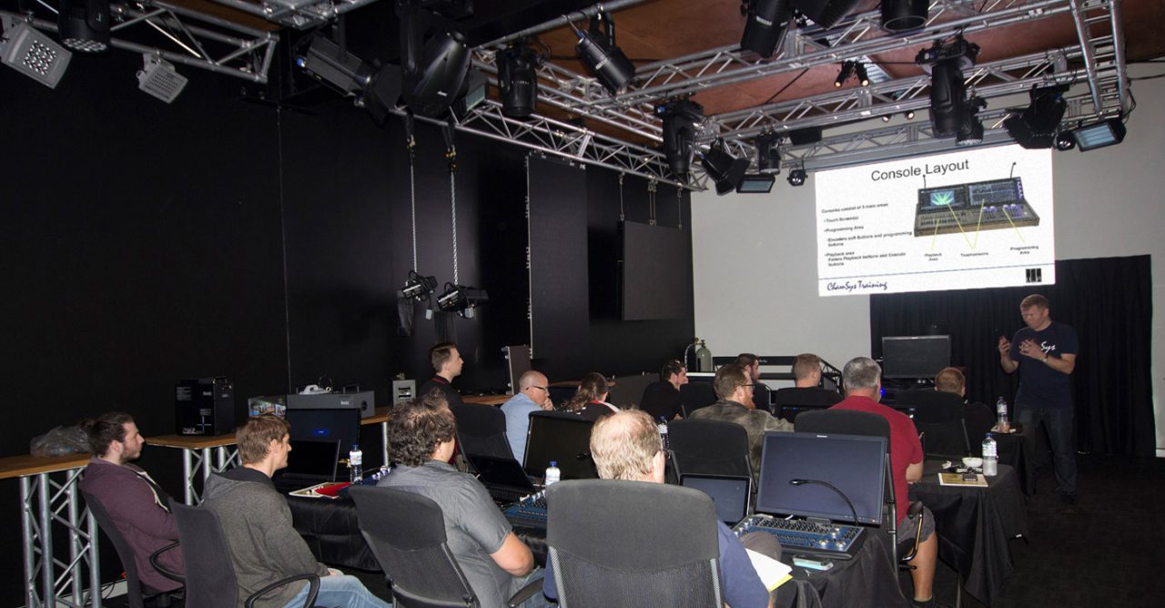Participants watching a projected demonstration in a lighting showroom.