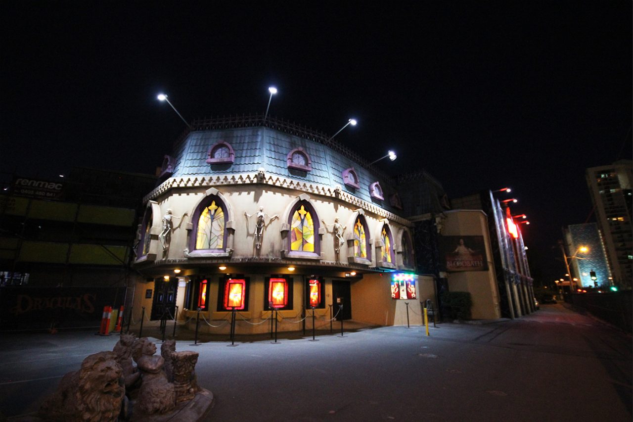 White lighting across Dracula's facade and upper windows at night.