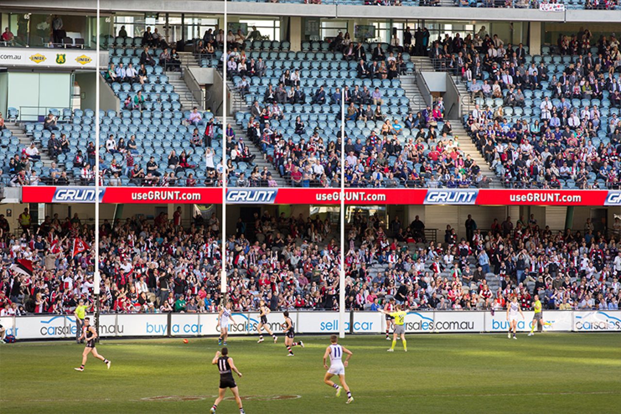 Red advertising ribbon across the crowded stands at Etihad Stadium.