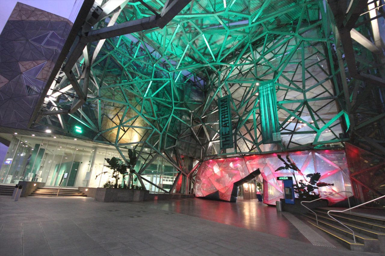 Green lighting across Federation Square's atrium above the public walkway.