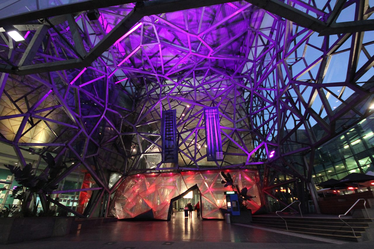 Purple lighting through the geometric atrium structure at Federation Square.
