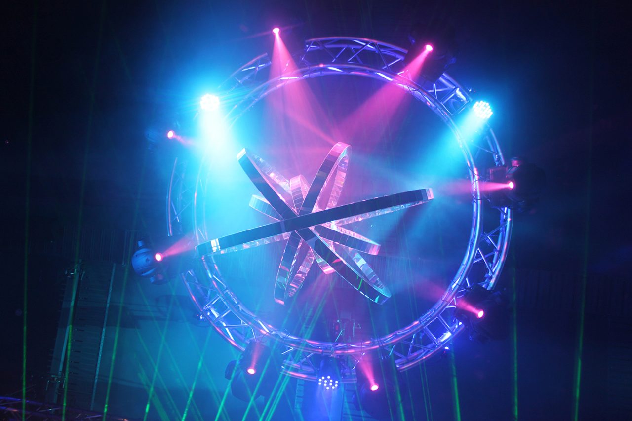 Pink and blue beams around a circular overhead lighting rig at the GH Hotel.