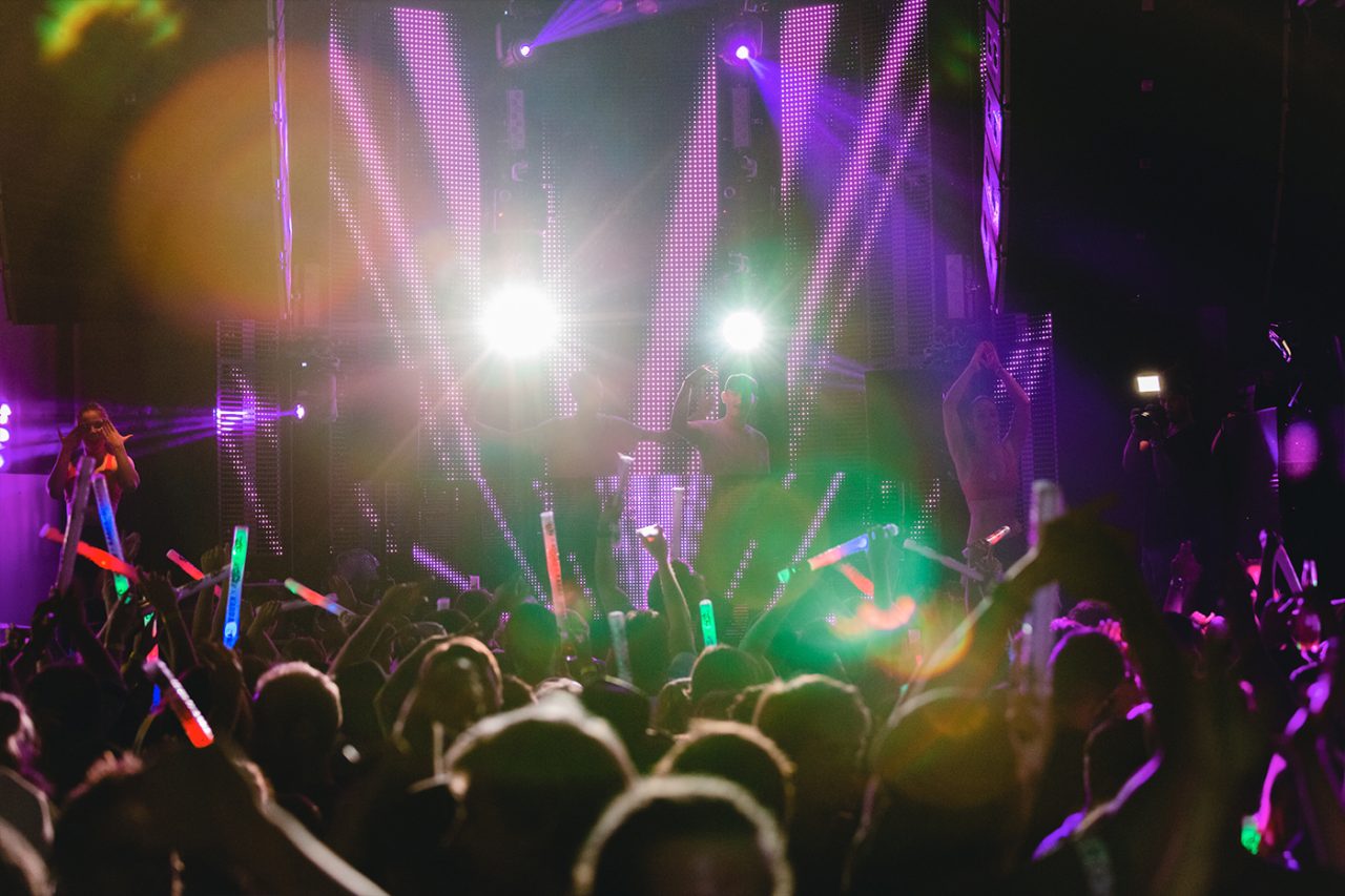 Purple and gold beams over the crowd at Gilligan's resort.