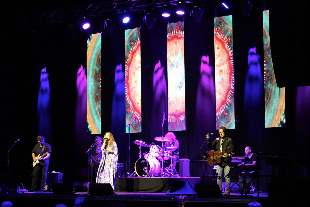 Band performs beneath colourful vertical video screens at Gladstone Entertainment Centre.