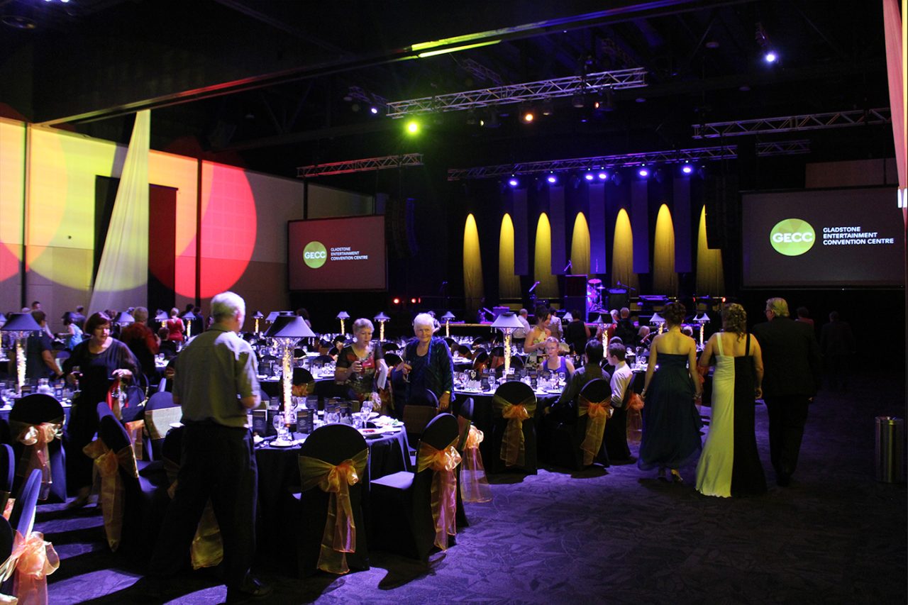 Wide view of a banquet and illuminated stage columns at Gladstone Entertainment Centre.