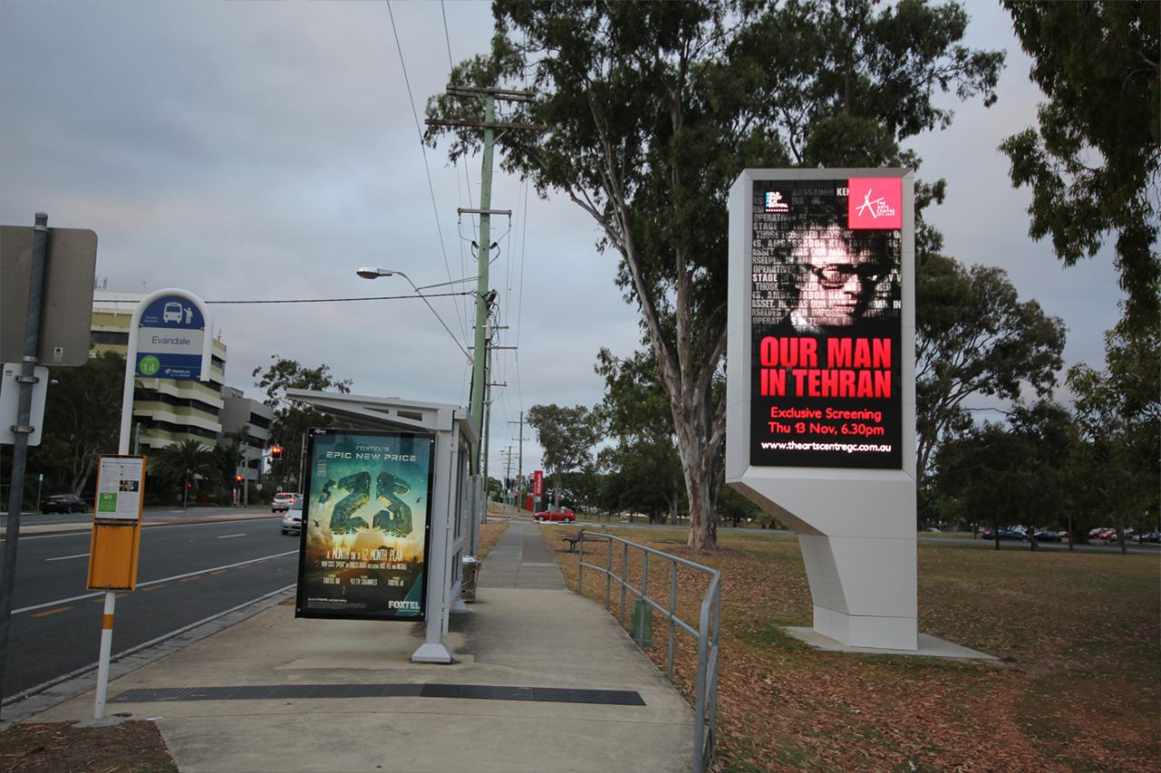 HOTA's roadside digital event sign beside a bus stop.