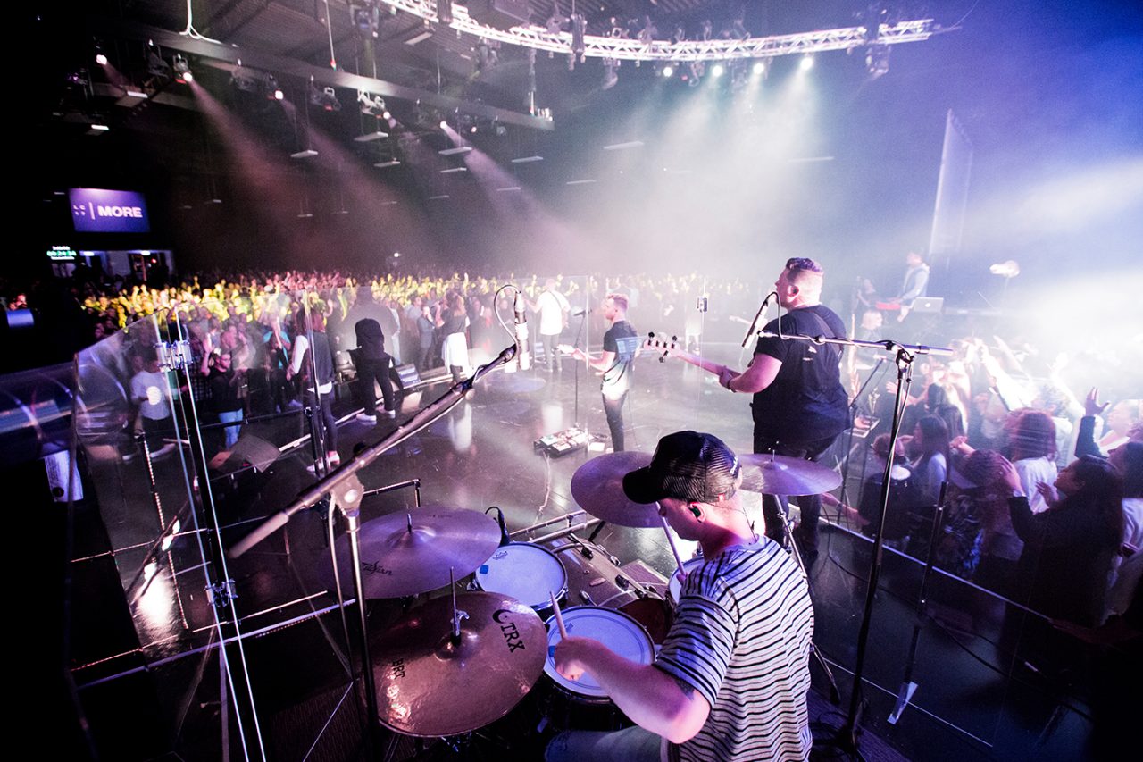 Drummer and musicians overlook the congregation from the Life Church stage.