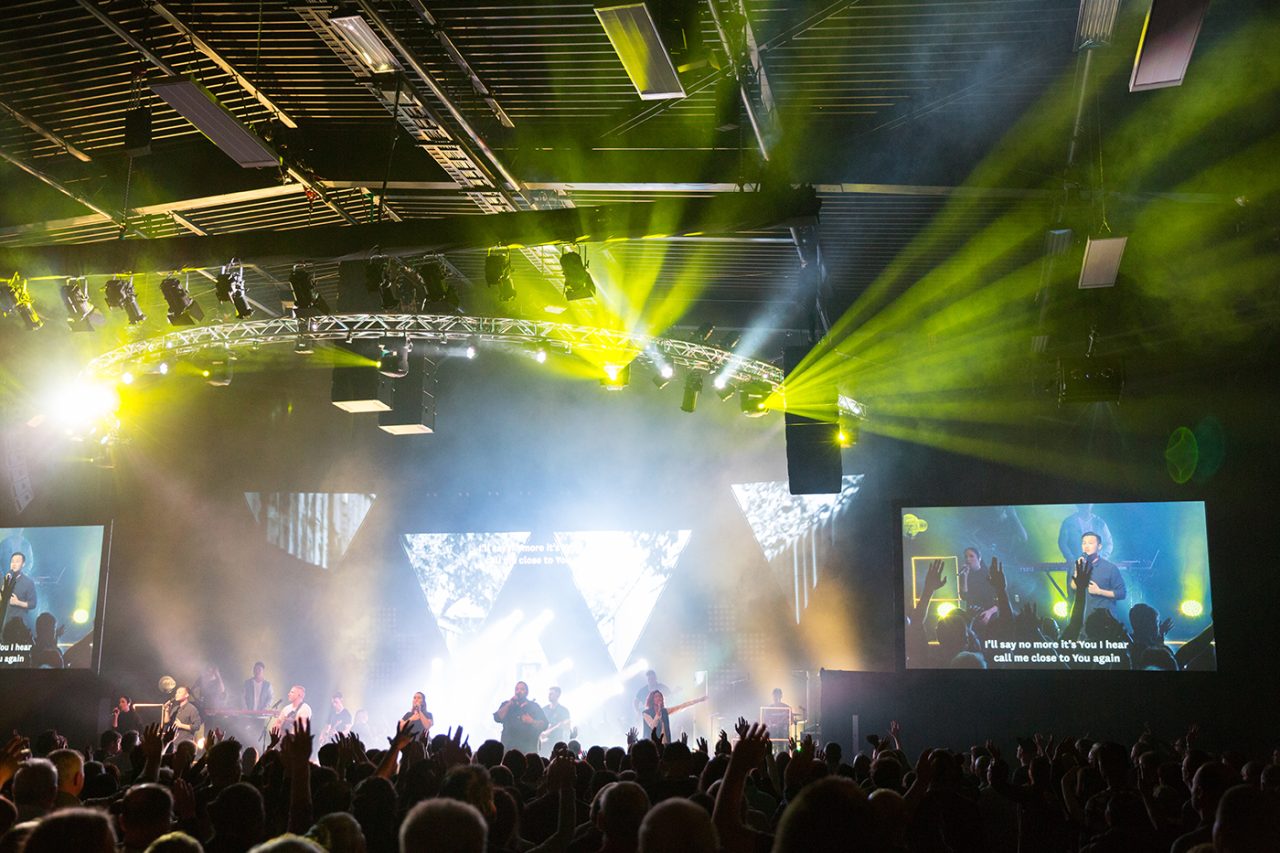 Green beams across the auditorium and live screens at Life Church.