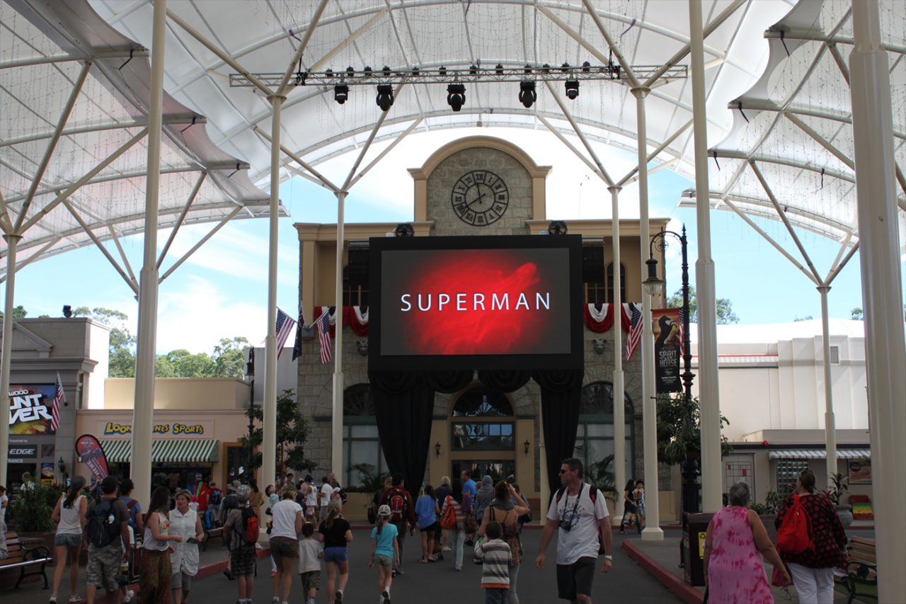 Superman branding on the large screen above visitors at Movie World.