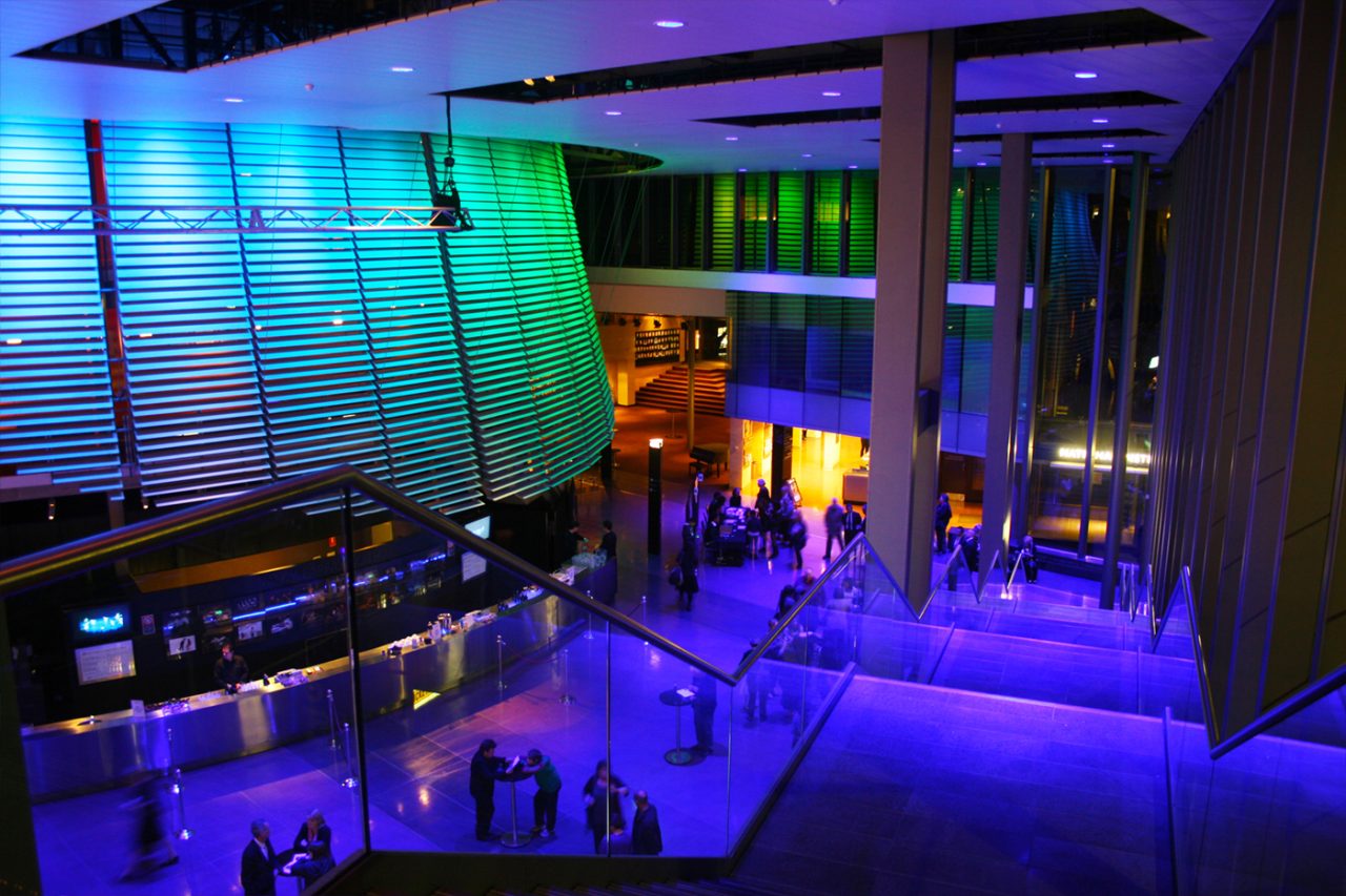 Blue and green lighting across the National Institute of Dramatic Art foyer.