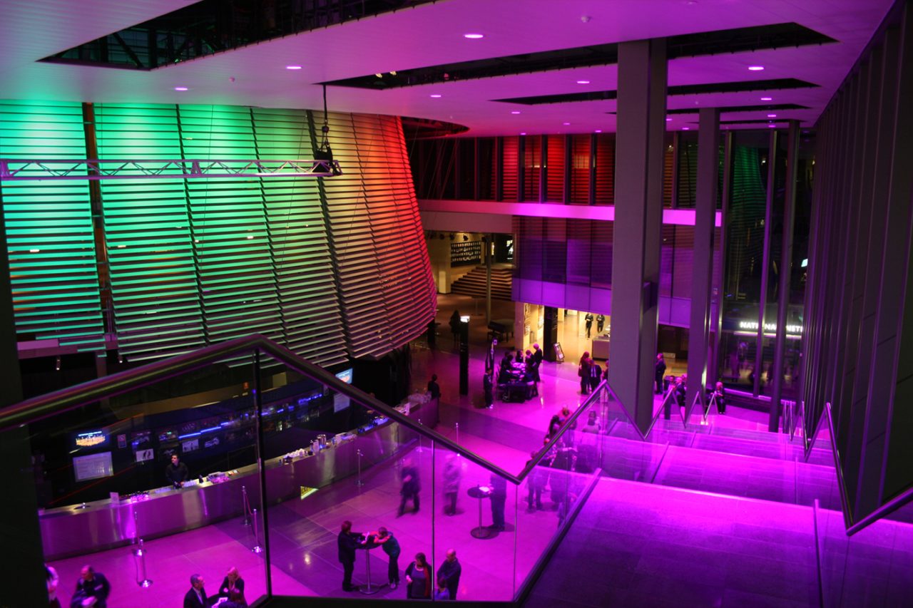 Pink and green architectural lighting around the NIDA foyer and entrance.