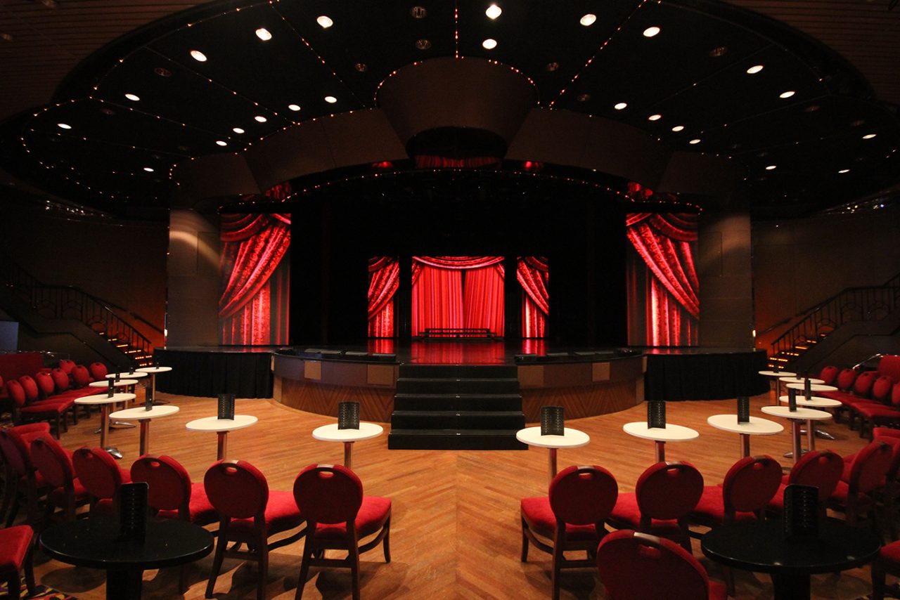 Red digital backdrop and side columns in the Pacific Aria theatre.