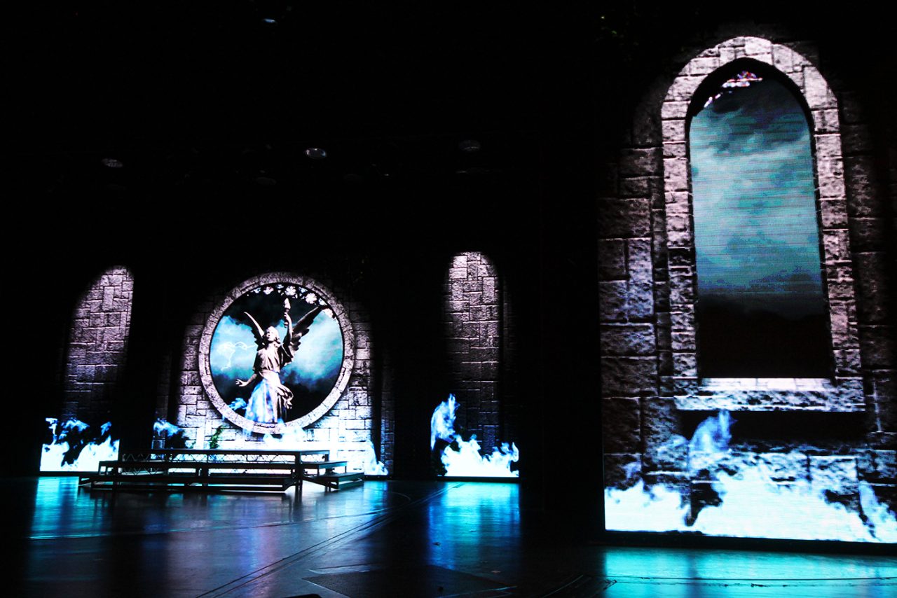 Close view of virtual stone arches and blue scenery on the Pacific Eden theatre screens.
