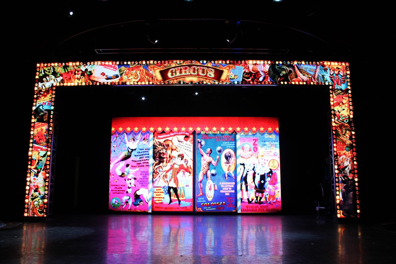 Colourful show graphics across the Pacific Jewel theatre's screen frame and backdrop.